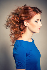 Fototapeta premium Girl with red hair and a bun after hairdressing