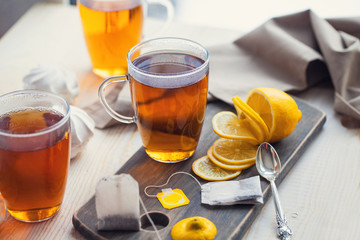 Shot of glass cup of tea with lemon on wood table