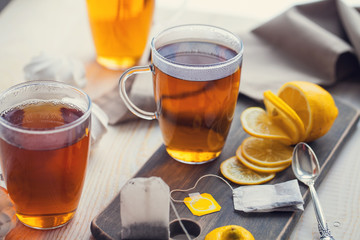 Shot of glass cup of tea with lemon on wood table
