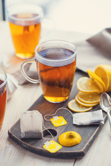 Shot of glass cup of tea with lemon on wood table