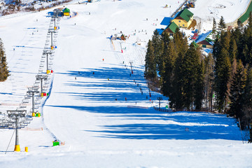 Chairs on chairlift ropeway in winter mountains