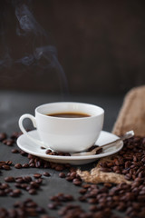 Coffee cup and saucer on a wooden table. Grey background