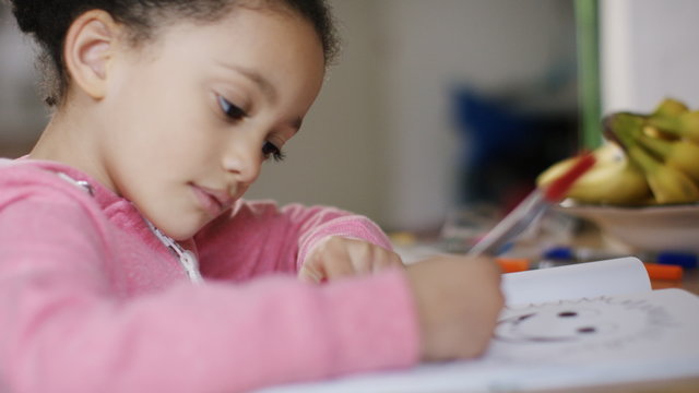 Young girl colouring in with coloured pens