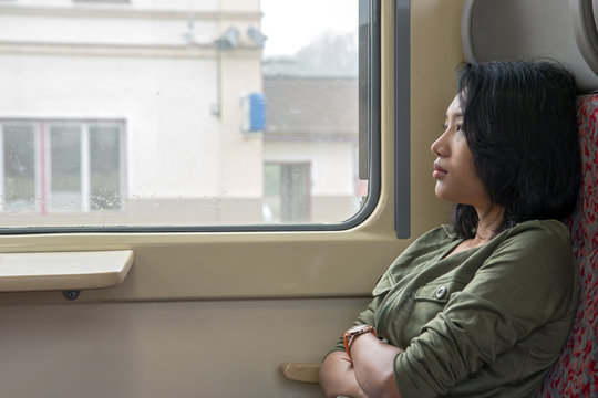 A young woman looks out the window at railway station