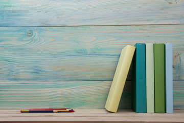 Back to school. Stack of colorful books on wooden table. Copy space