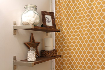 Decorated wooden bathroom shelves with yellow shower curtain