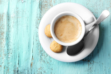 Cup of coffee on color wooden background