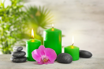 Obraz na płótnie Canvas Green candles with spa stones and bamboo on table