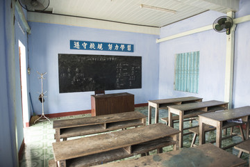 Aula de una escuela vietnamita con bancos y muebles de madera. Hoian, Vietnam 