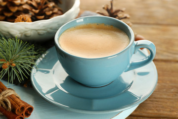 Cup of coffee and Christmas tree branch on wooden mat