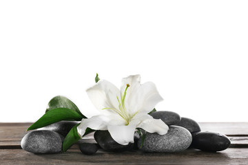 Obraz na płótnie Canvas Beautiful white lily and spa stones on white background