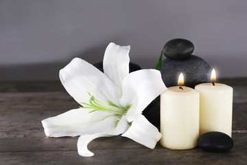 Fototapeta na wymiar Spa still life with beautiful flower and candlelight on wooden table closeup