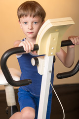 The child is trained on a stationary bike . Healthy lifestyle.