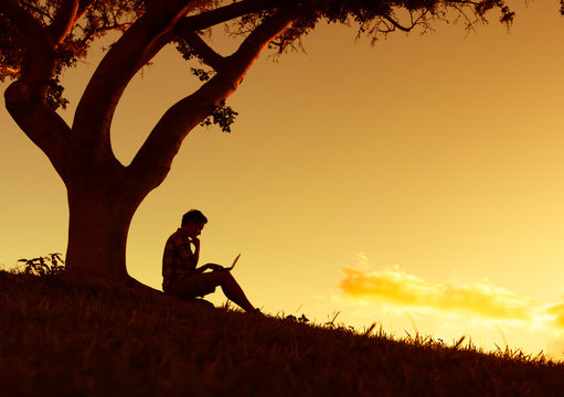 Young man using in laptop in the park.