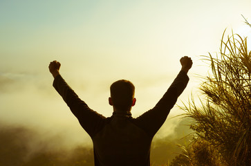 Success achievement running or hiking accomplishment business and motivation concept with man sunset silhouette celebrating arms up raised outstretched trekking climbing running outdoors in nature
 - Powered by Adobe