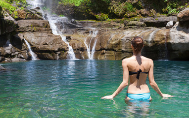 Young woman going for a swim in a beautiful natural spring. 