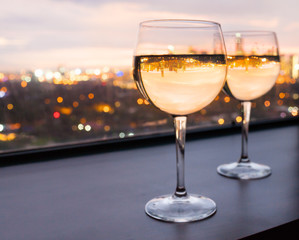 Pair of wine glasses and city view. 