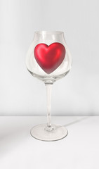 valentine red heart in wine glass on gray