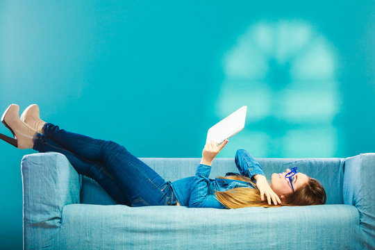 Woman With Tablet Relaxing On Couch Blue Color