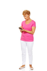 Serious senior woman with smartphone