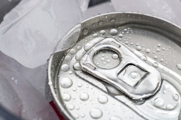 Top of aluminum cans of soda pop covered in ice and droplets of water