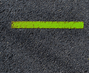 Fototapeta premium grungy, dirty view of asphalt with distinct green stripe