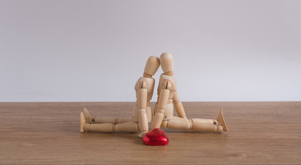 A wooden doll man with heart-shaped chocolate in valentine day compose with love
