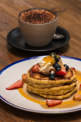 pancakes stack with cappuccino on wooden table