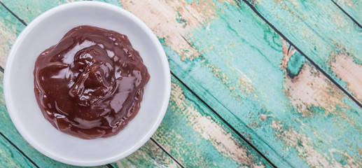 Raspberry fruit curd in white bowl over wooden background