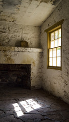 interior of a stone house with light shining through the window.