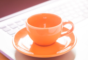 Closeup coffee cup on laptop