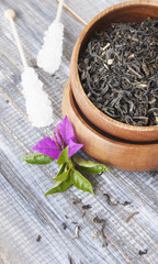 leaf green tea in wooden bowl with sugar on stick