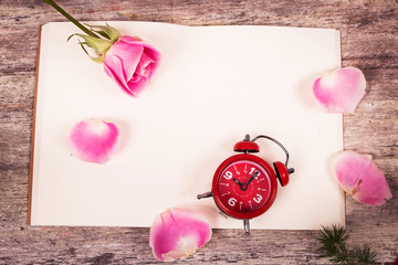 pink rose flower and watch on note book wooden background