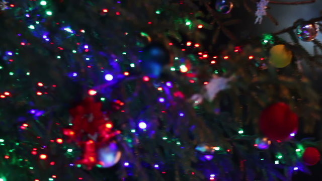 Christmas tree decorated with lights, toys at night.
