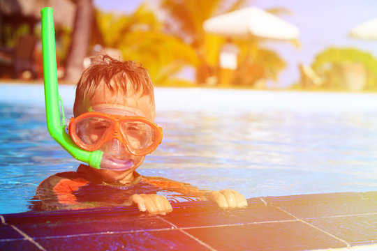 little boy swimming with mask in pool