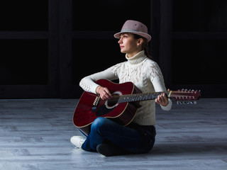girl with guitar sitting on the floor