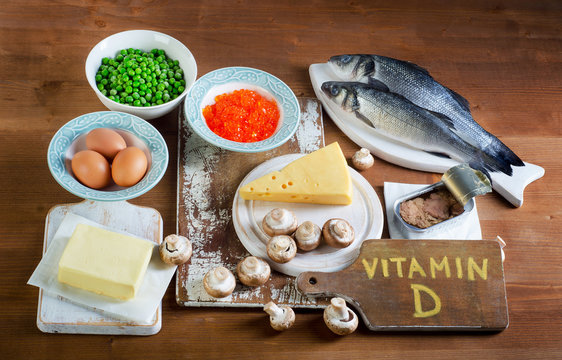 Food sources of vitamin D on a wooden background.