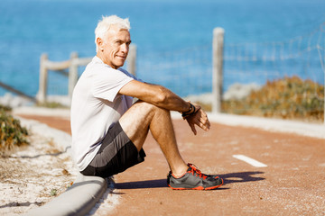 Man in sports wear sitting at the beach