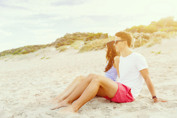 Romantic young couple sitting on the beach