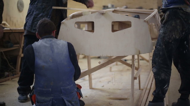 Carpenters build a boat at the shipyard, collected forstein, stringer, transom, frames
