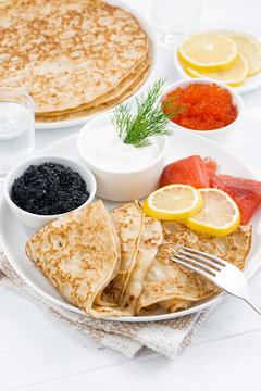 Traditional crepes with fish, sour cream and caviar, vertical