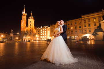 Obraz premium The night is young. Soft focus full length shot of a young happy married couple hugging on the central city square
