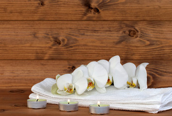 Fototapeta na wymiar Handtuch mit Orchidee und Kerzen