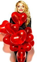 portrait of beautiful happy sweet smiling blonde woman girl holding in her hands red heart balloons in casual black hipster clothes