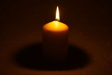 Single candle on tablecloth
Single candle burning on table with beige embroidered tablecloth
