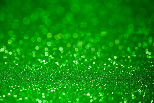 Green glitter surface with green light bokeh - It can be used for background for special occasions promotion campaign or product display