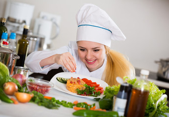 Positive chef posing with vegetable mix and cheese