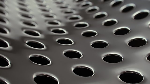 A looping clip of a slowly rotating, elegant surface of perforated metal.
