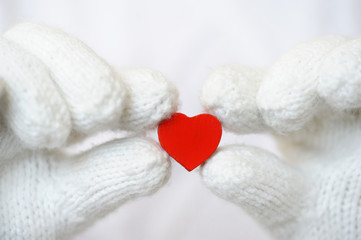Red heart in white gloves.