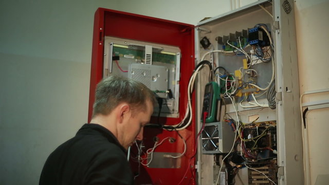 The scientist makes in the switchboard electrical measurements with a multimeter
